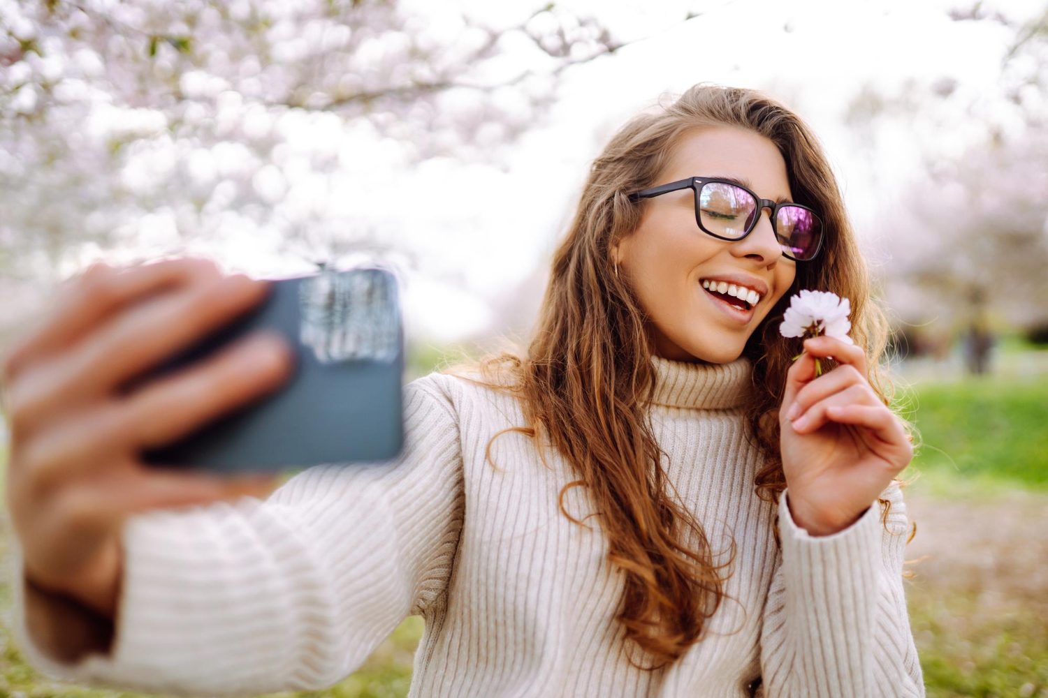girl takes selfie with flower in hand